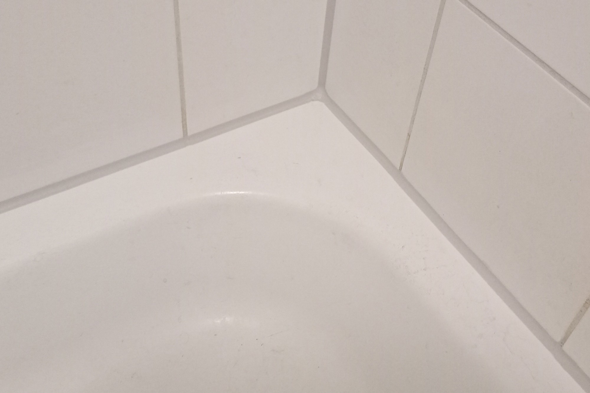 Kitvoeg tussen douchebak en wandtegels, zilvergrijs afgewerkt