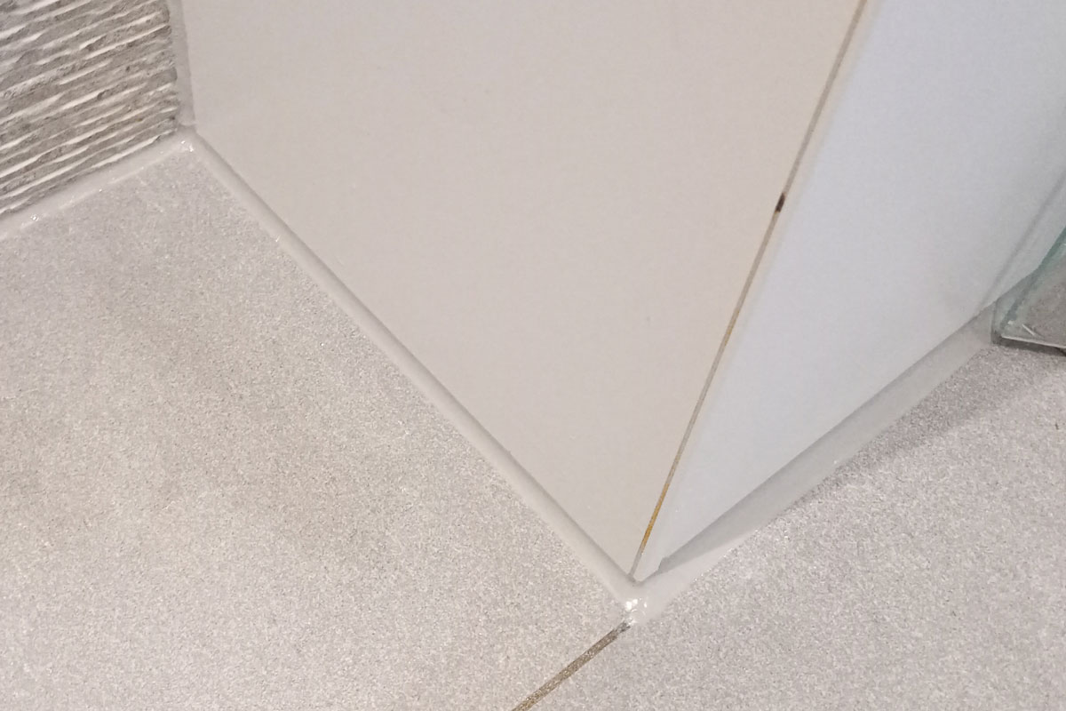 Lichtgrijze kitvoeg tussen badkamervloer en wand in Eindhoven
